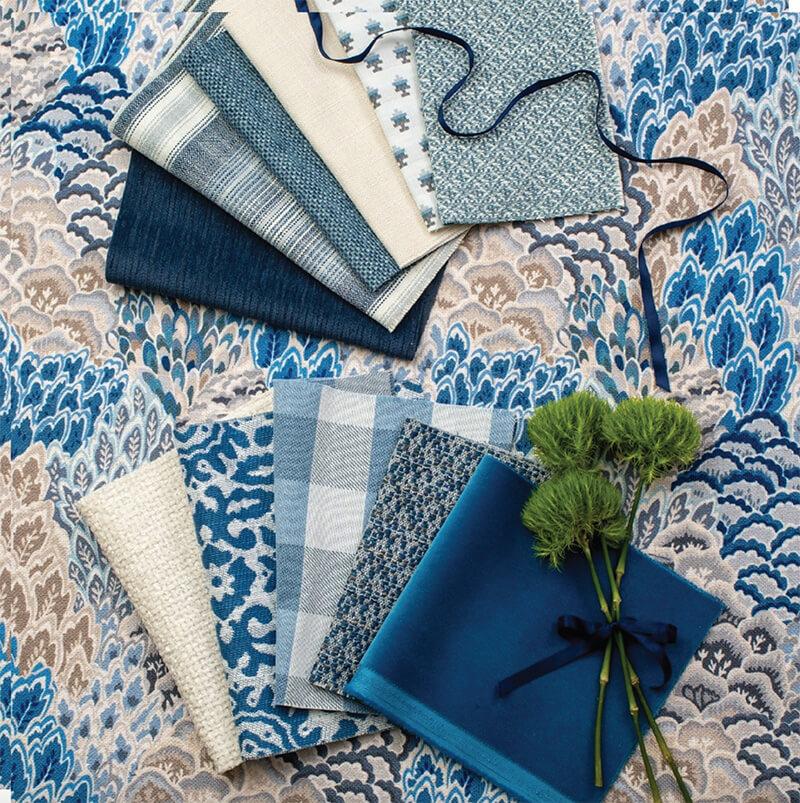 a variety of blue fabric samples laid out across a table 